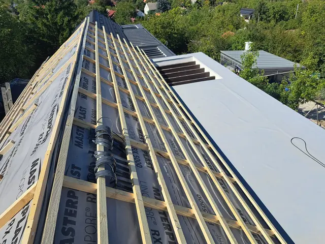 Alátétfólia és lécezés a magastetőn, mellette a kész PVC lapostető