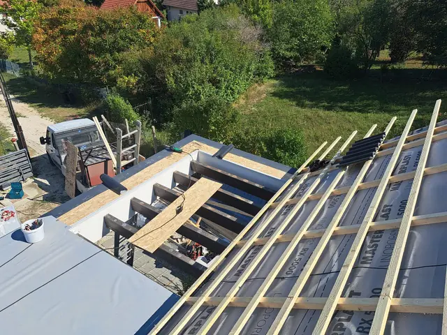 Lécezés a magastetőn és a lapostető csatlakozása, munka közben