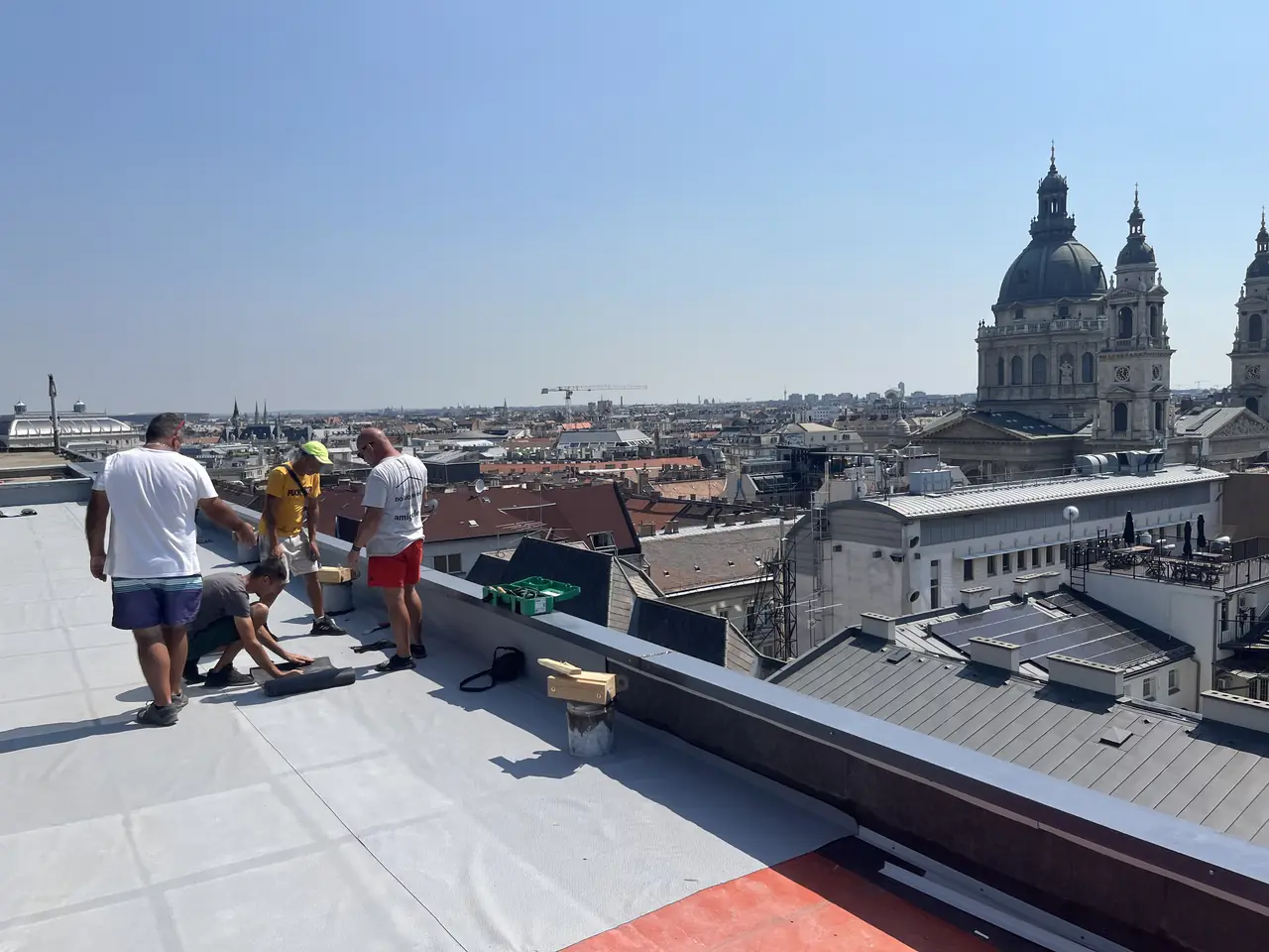 A Minden Tető csapata egy belvárosi irodaház lapostetőjén, a háttérben a Szent István-bazilika