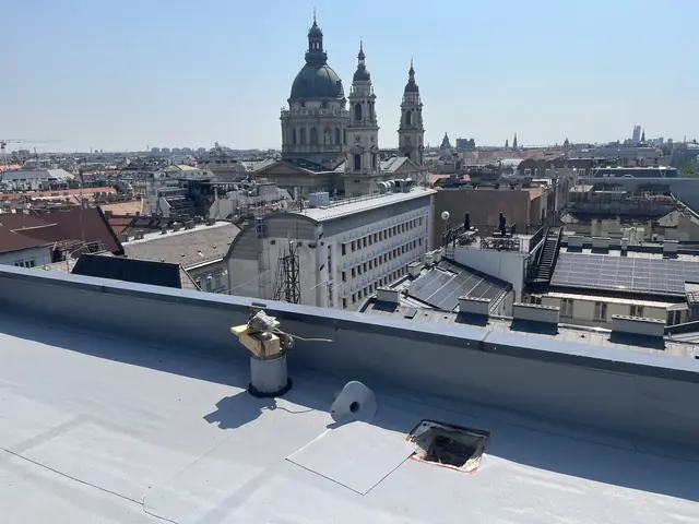 Szellőző a PVC lemezzel szigetelt tetőn, az attikafal mögött a belváros