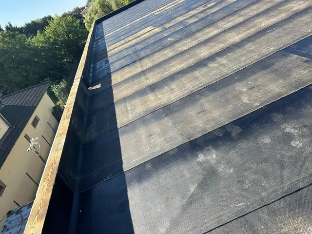 A lemez felvezetése a szegélyre a lapostető hosszanti oldalán